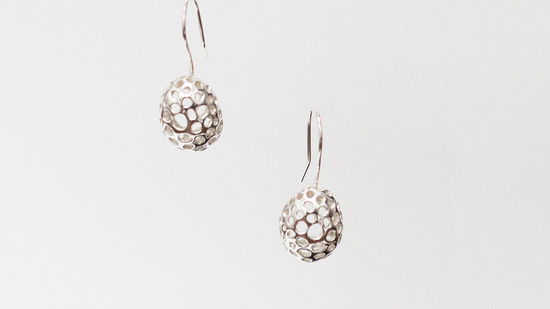 Pendientes de plata limpios y brillantes tras su limpieza, ejemplo de cómo mantener joyas de plata en casa