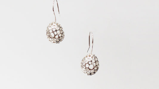 Pendientes de plata limpios y brillantes tras su limpieza, ejemplo de cómo mantener joyas de plata en casa